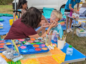 A young boy gets his face painted