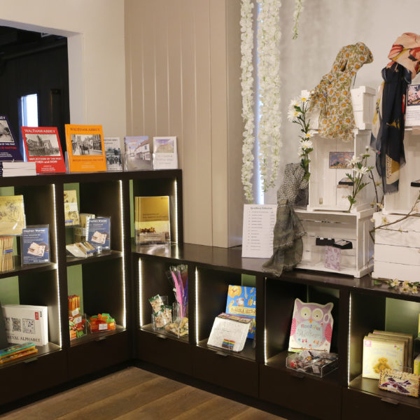 A collection of books, gifts and paintings on the shelves of the museum gift shop