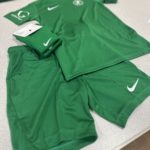 Limes Farm Football Club Kit. Green shirt, shorts and scocks laid out on display